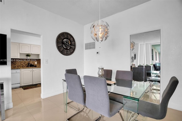 dining area featuring sink, an inviting chandelier, and light tile patterned floors