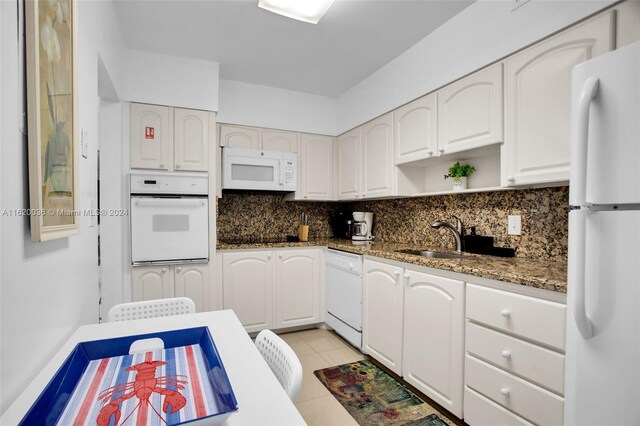 kitchen featuring white cabinetry, decorative backsplash, white appliances, and light tile patterned floors