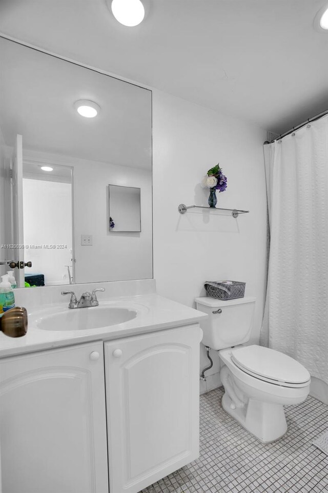 bathroom featuring vanity, toilet, and tile patterned flooring