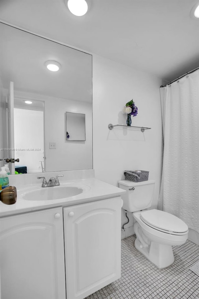 bathroom with tile patterned flooring, vanity, curtained shower, and toilet