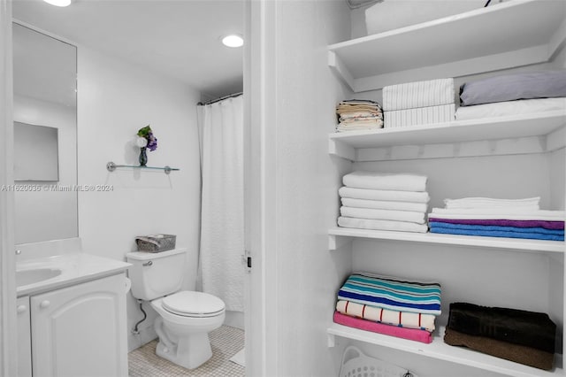 bathroom featuring vanity, tile patterned floors, and toilet