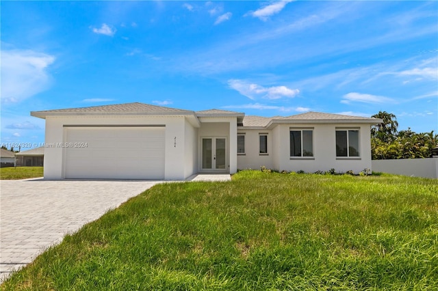 ranch-style house with a garage, a front lawn, and french doors