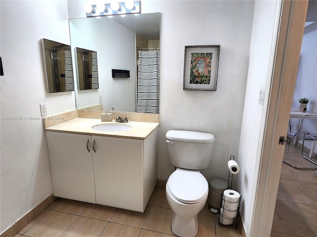 bathroom with tile patterned flooring, vanity, and toilet