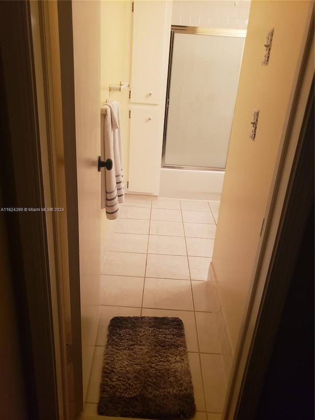 bathroom with tile patterned flooring and a shower with shower door