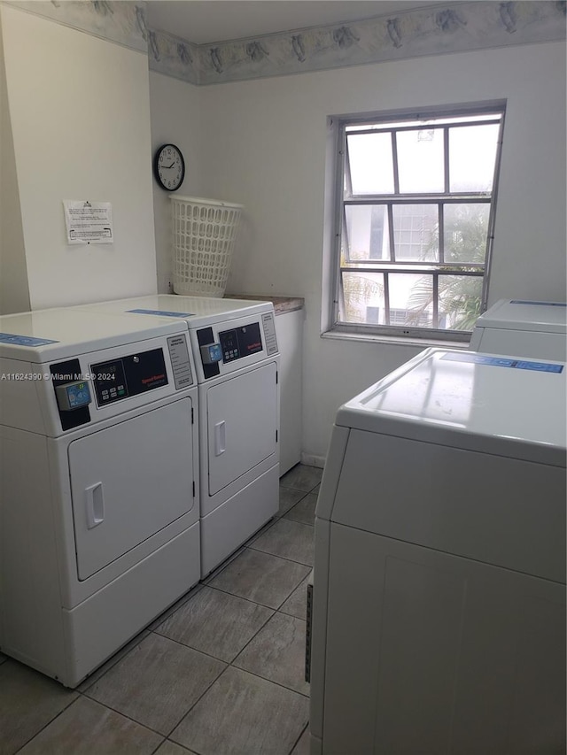 laundry room with washing machine and clothes dryer and light tile patterned floors