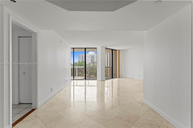 tiled spare room featuring expansive windows