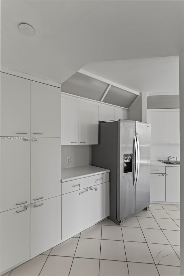 kitchen featuring sink, white cabinets, stainless steel refrigerator with ice dispenser, and light tile patterned floors