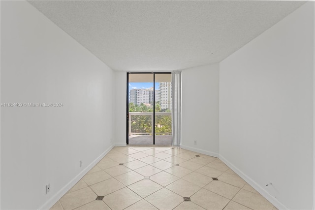 20185 E Country Club Dr Unit 502, Aventura, FL 33180 - unfurnished room featuring a textured ceiling, expansive windows, a city view, and baseboards
