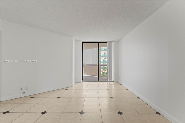 20185 E Country Club Dr Unit 502, Aventura, FL 33180 - empty room with a textured ceiling, a wall of windows, and baseboards