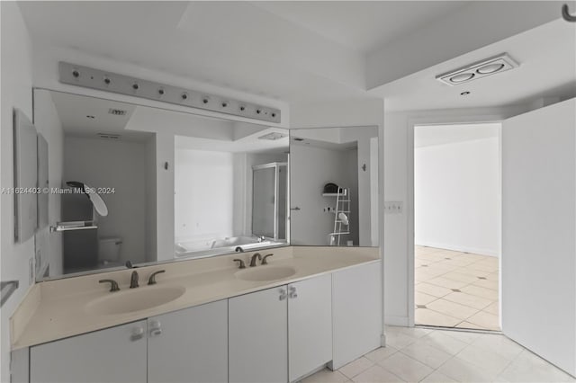 bathroom with toilet, tile patterned floors, and dual bowl vanity