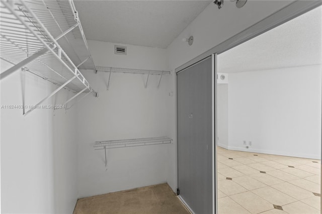 walk in closet featuring light tile patterned flooring