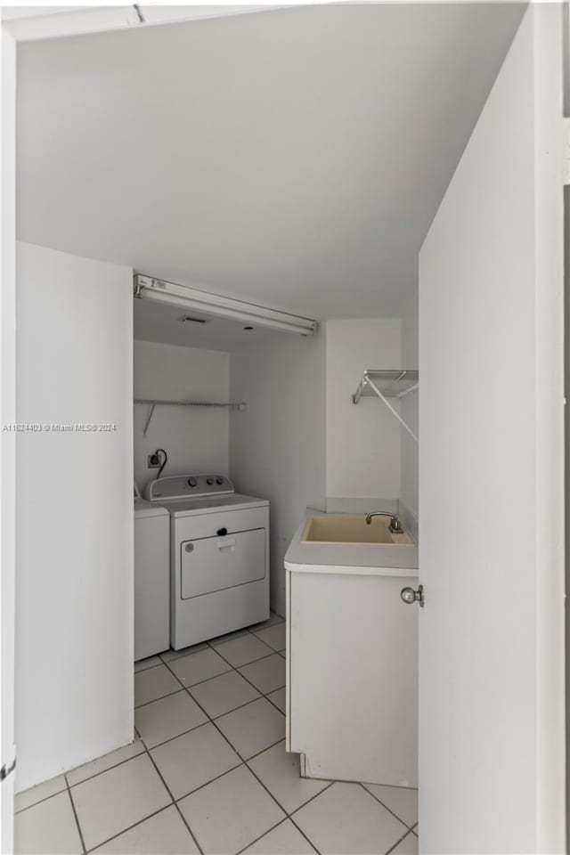 bathroom with tile patterned floors, washing machine and dryer, and sink