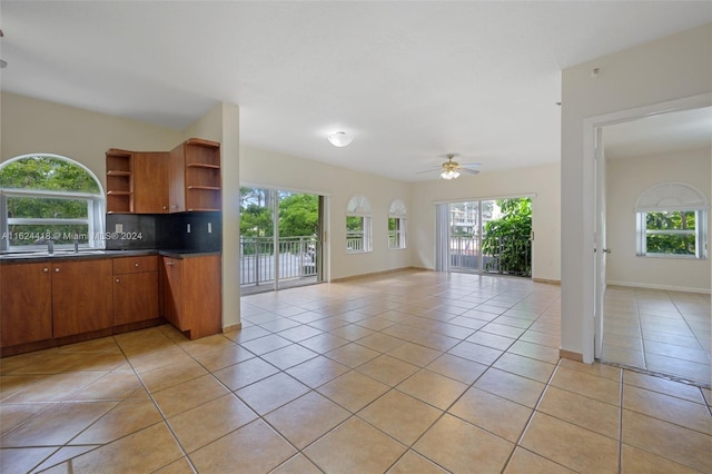 kitchen with ceiling fan, sink, light tile patterned floors, and tasteful backsplash