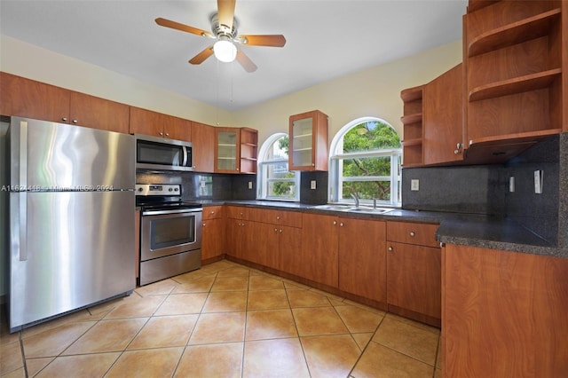 kitchen featuring appliances with stainless steel finishes, sink, decorative backsplash, ceiling fan, and light tile patterned flooring