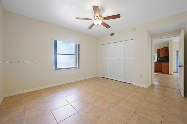 unfurnished bedroom featuring a closet, ceiling fan, and light tile patterned floors