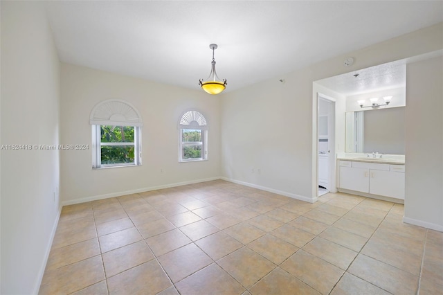 unfurnished room featuring light tile patterned floors and sink