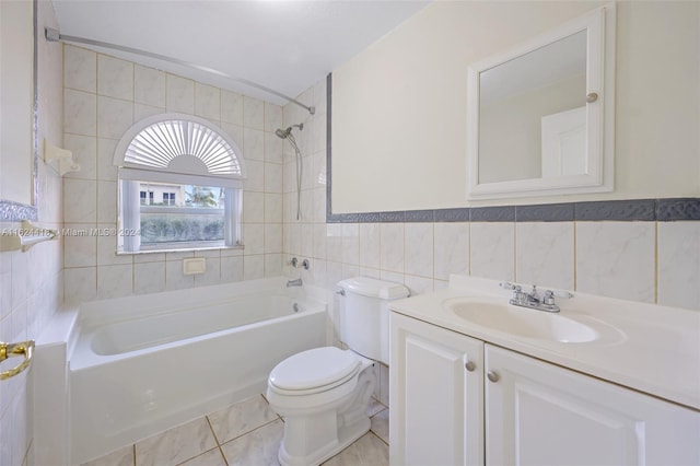 full bathroom with tile patterned flooring, toilet, tile walls, tiled shower / bath combo, and vanity