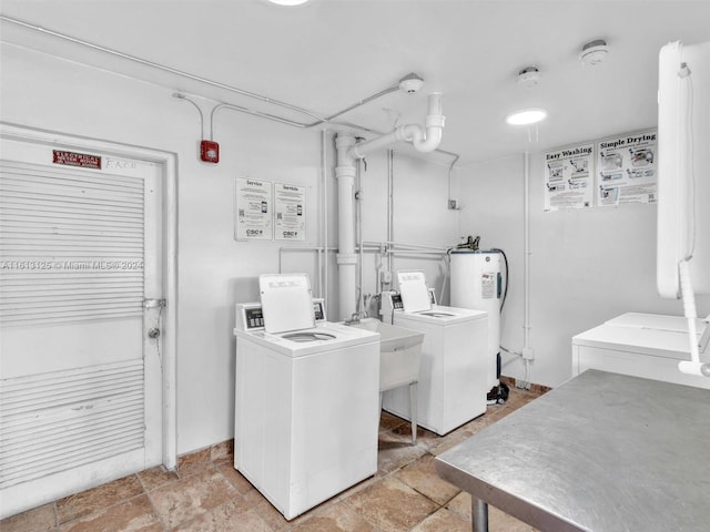 washroom with washing machine and dryer, electric water heater, and sink