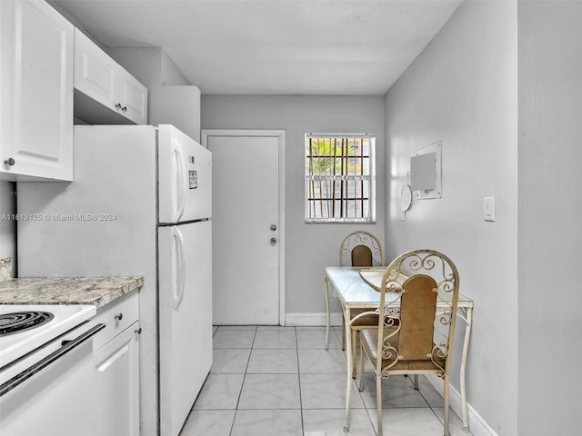 kitchen featuring white cabinetry, light stone counters, and light tile patterned flooring