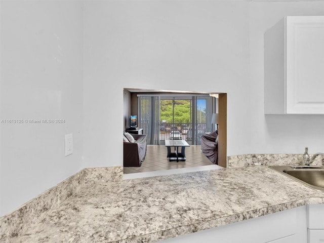 kitchen featuring white cabinetry, sink, and a high ceiling