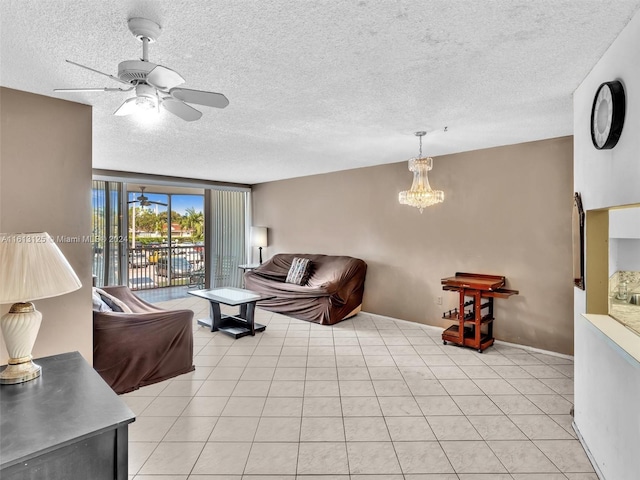 living room featuring light tile patterned flooring, ceiling fan with notable chandelier, and a textured ceiling