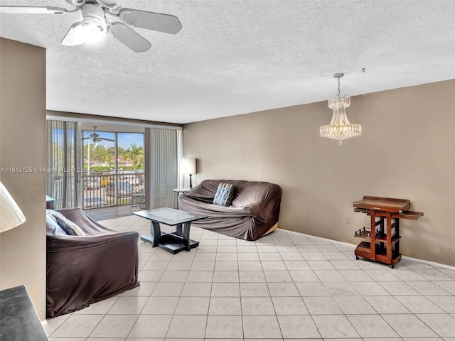 tiled living room featuring ceiling fan with notable chandelier and a textured ceiling