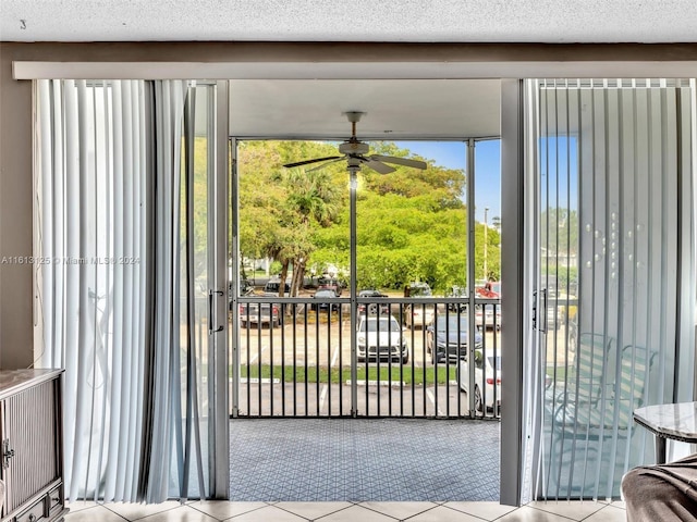 doorway to outside with a textured ceiling and ceiling fan