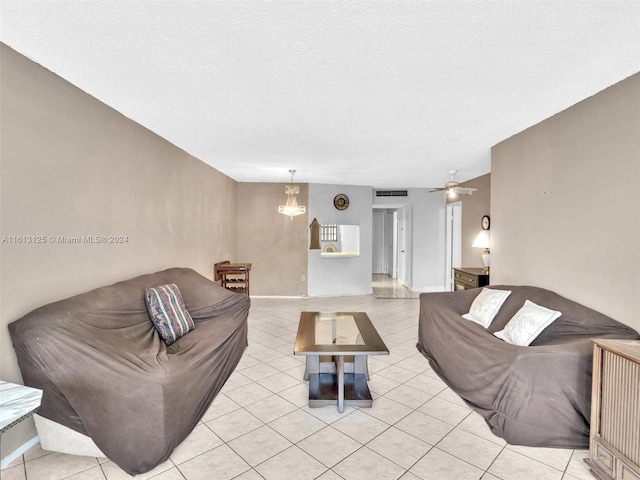 tiled living room featuring ceiling fan and a textured ceiling