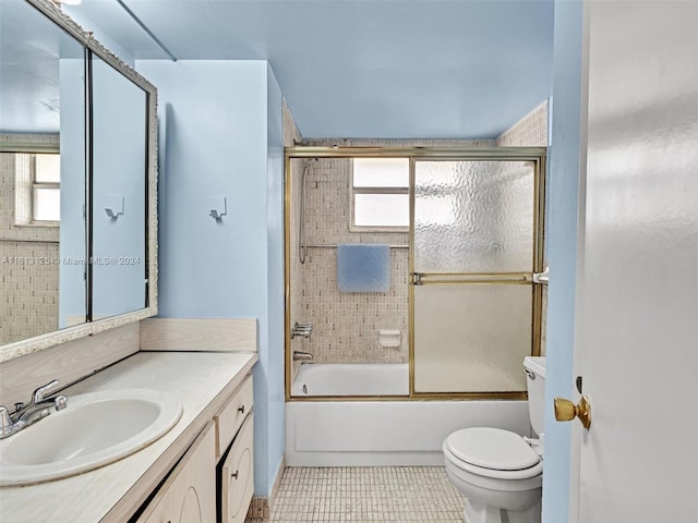 full bathroom with tile patterned flooring, bath / shower combo with glass door, vanity, and toilet