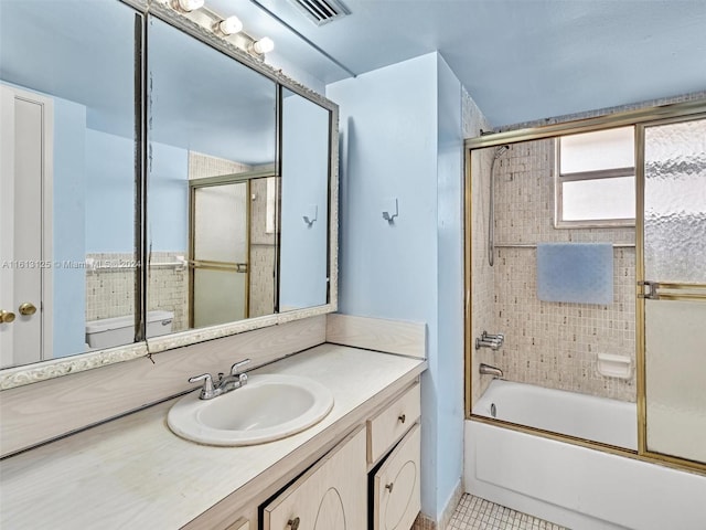 full bathroom featuring vanity, tile patterned flooring, bath / shower combo with glass door, and toilet