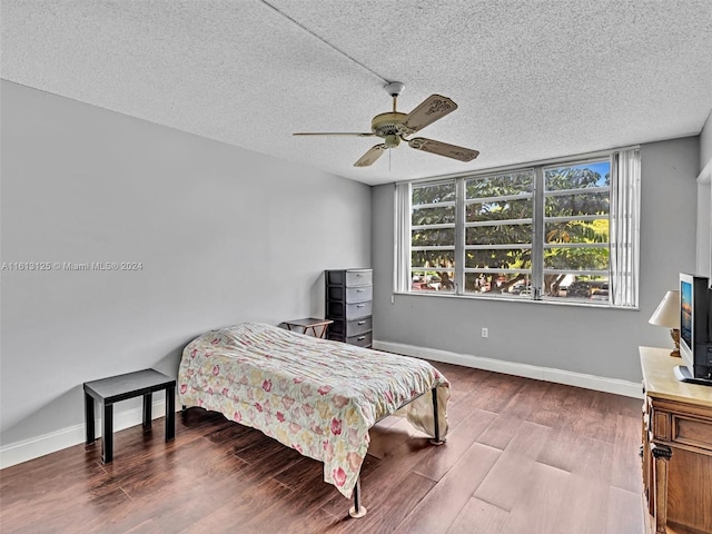 bedroom with hardwood / wood-style flooring, ceiling fan, and a textured ceiling