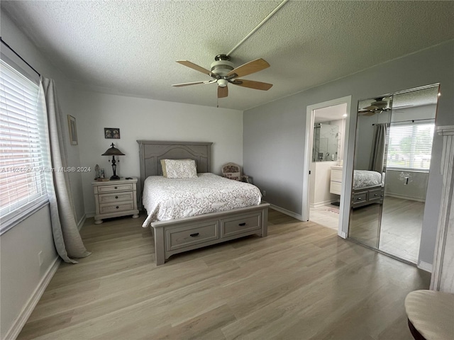 bedroom with ensuite bath, a textured ceiling, ceiling fan, and wood-type flooring