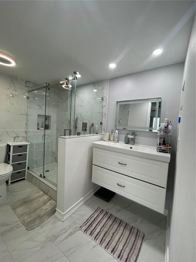 bathroom with vanity, a shower with door, tile patterned flooring, and toilet