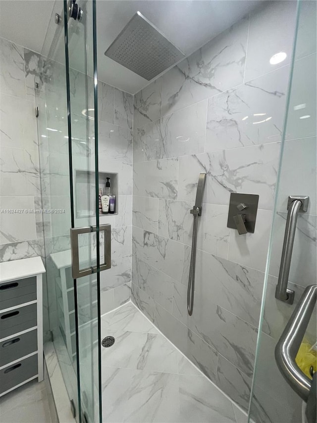 bathroom with a shower with shower door and vanity