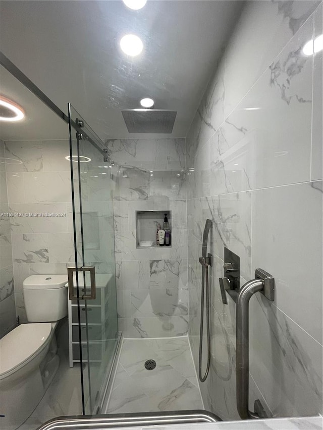 bathroom with toilet, an enclosed shower, and tile walls