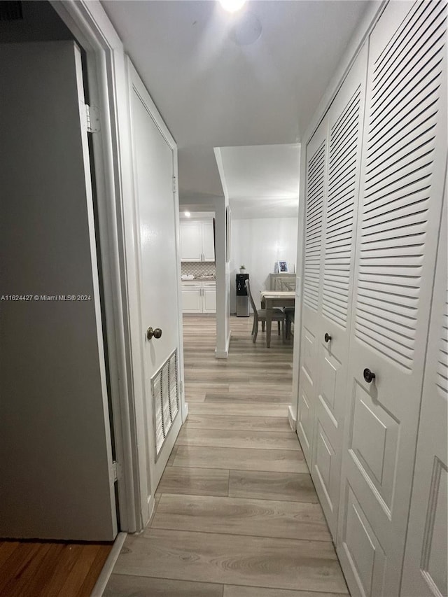 corridor with light hardwood / wood-style floors