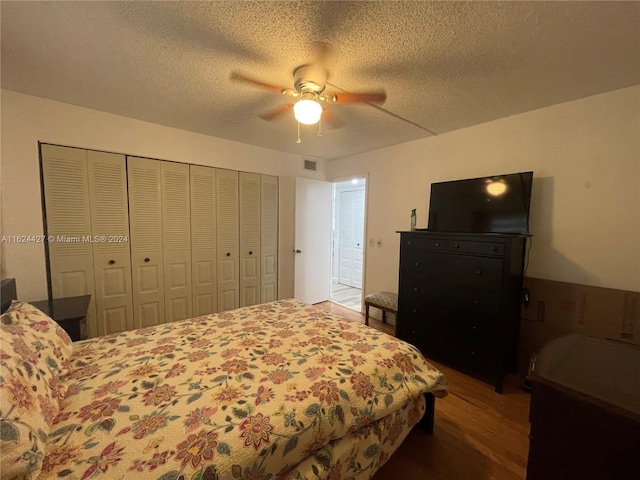 bedroom featuring ceiling fan, a textured ceiling, hardwood / wood-style flooring, and a closet