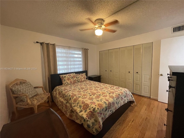 bedroom featuring ceiling fan, a textured ceiling, hardwood / wood-style flooring, and a closet