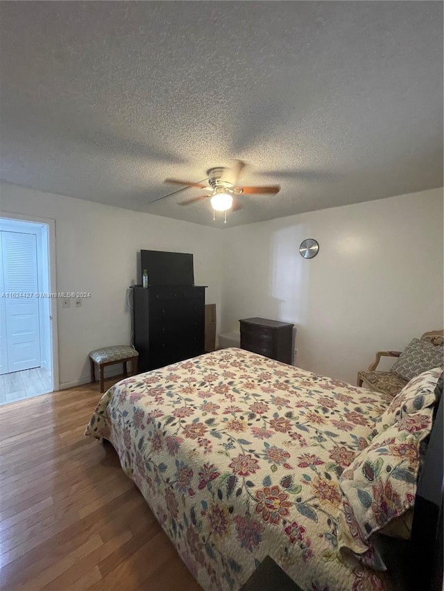 bedroom featuring a textured ceiling, hardwood / wood-style flooring, and ceiling fan