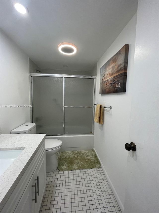 full bathroom featuring tile patterned flooring, shower / bath combination with glass door, toilet, and vanity