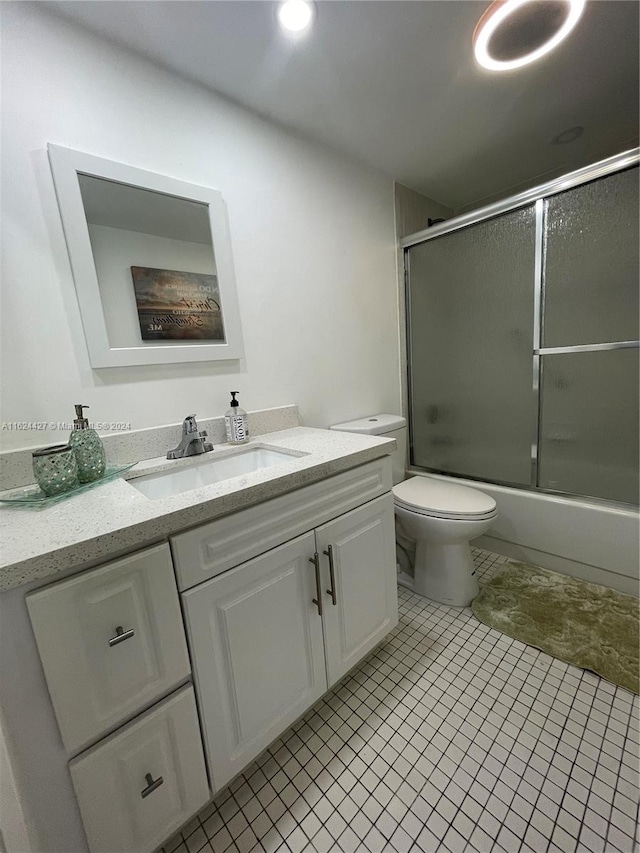 full bathroom with vanity, enclosed tub / shower combo, toilet, and tile patterned floors