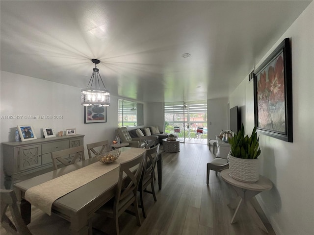 dining room featuring dark hardwood / wood-style flooring and an inviting chandelier