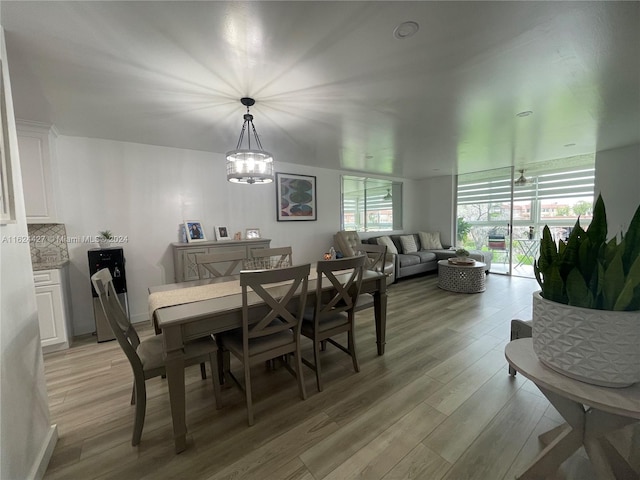 dining space featuring light hardwood / wood-style floors and a notable chandelier