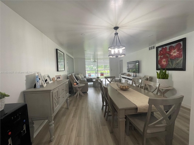 dining space featuring hardwood / wood-style flooring and a chandelier