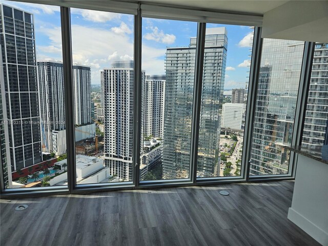 interior space with floor to ceiling windows and dark hardwood / wood-style floors