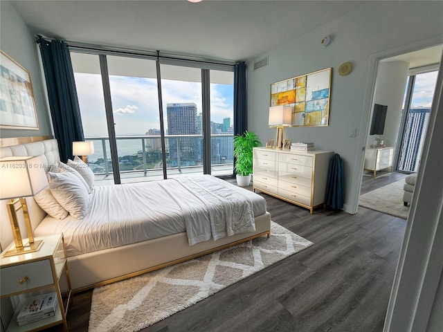 bedroom with floor to ceiling windows and dark hardwood / wood-style flooring