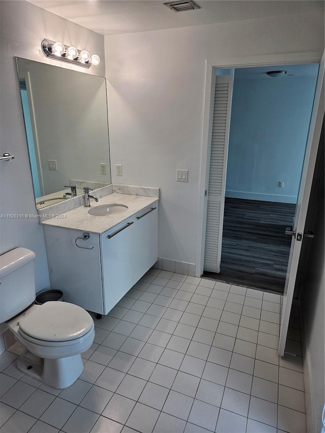 bathroom with tile patterned flooring, vanity, and toilet