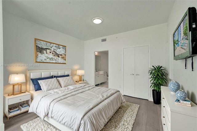 unfurnished bedroom featuring a closet, connected bathroom, and light hardwood / wood-style floors