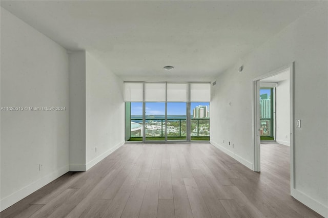 unfurnished living room with expansive windows and light hardwood / wood-style flooring