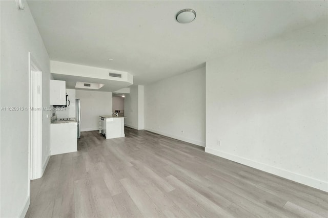 spare room featuring light wood-type flooring and expansive windows